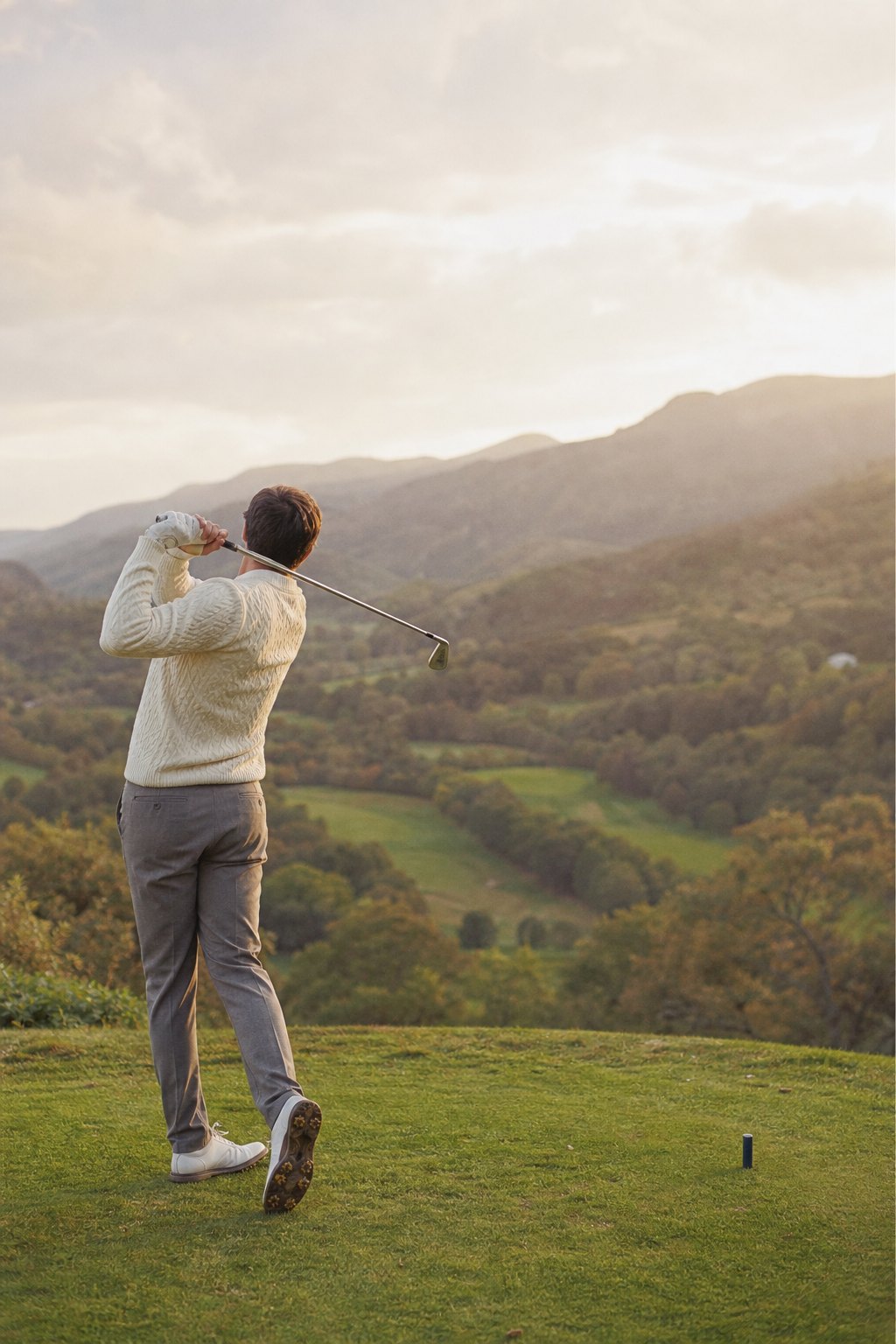 Golfer following through on a tee above a valley (AI-generated image)