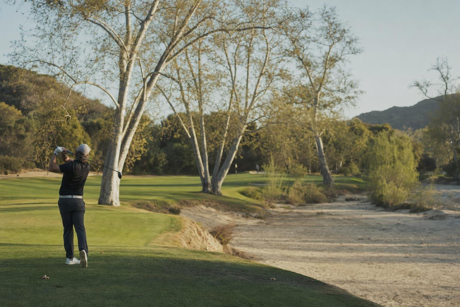 A golf hole running beside a dry sandy riverbed with sycamores and willows (AI-generated image)