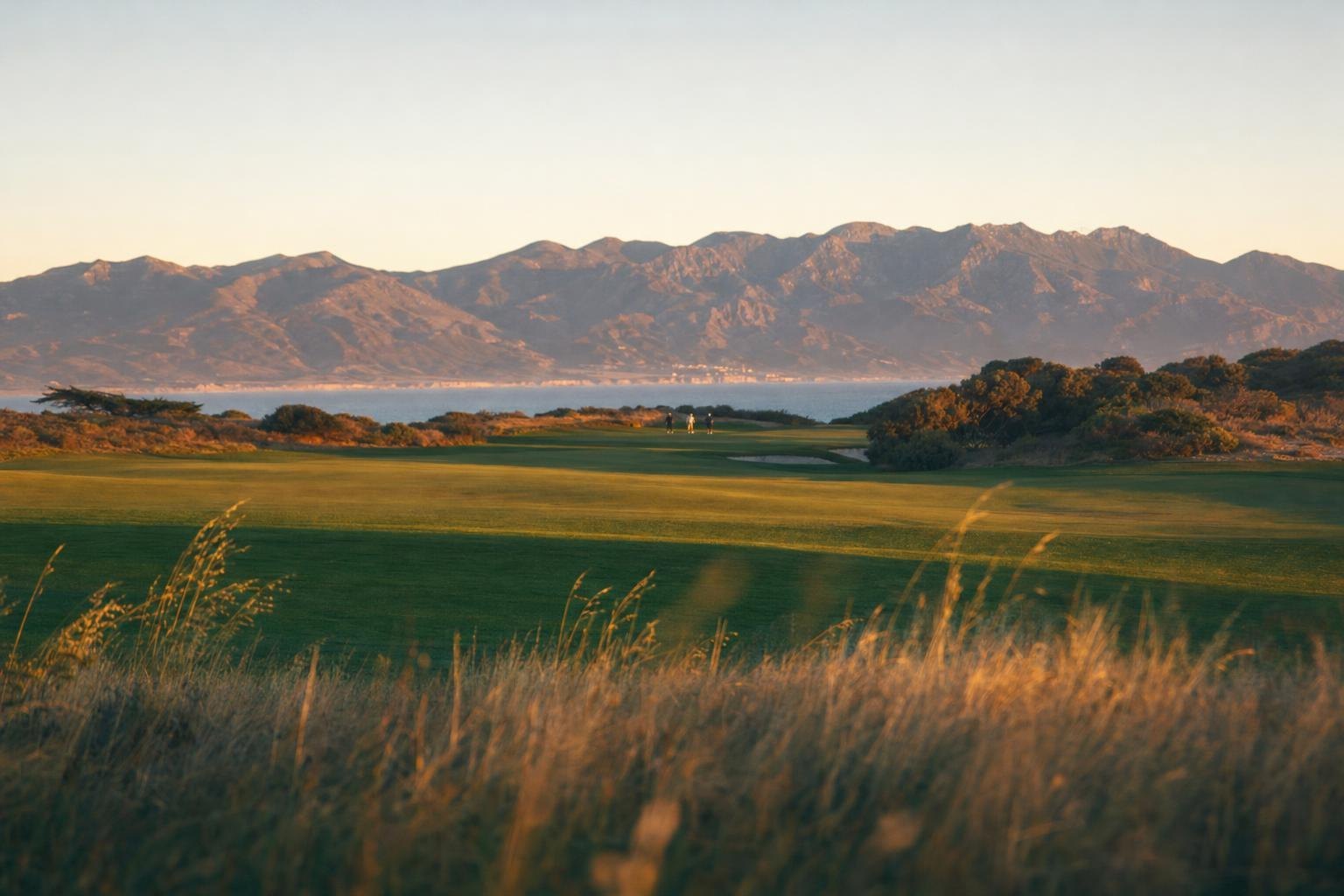 A finishing hole fairway at sunset with the rugged Los Padres mountain range on the horizon (AI-generated image)